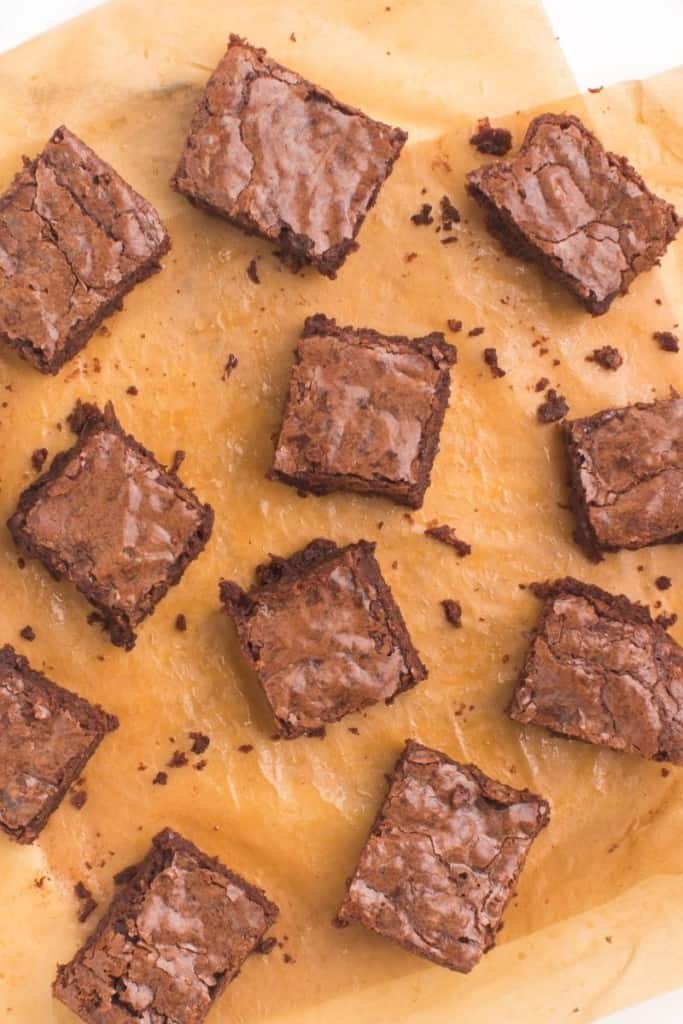 brownies without cocoa powder cut into squares on parchment paper