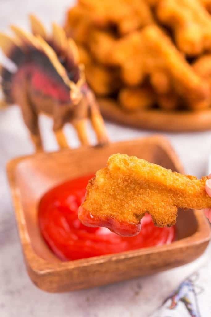 dino nugget dipped in ketchup