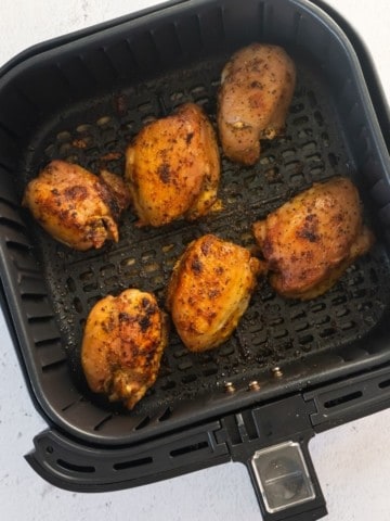 Frozen chicken thighs with lemon pepper seasoning in air fryer