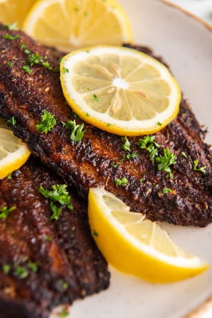 catfish fillets cooked in air fryer with lemon wedges as garnish