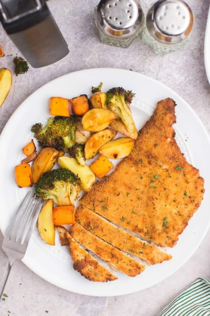 air fryer chicken cutlets on plate with veggies