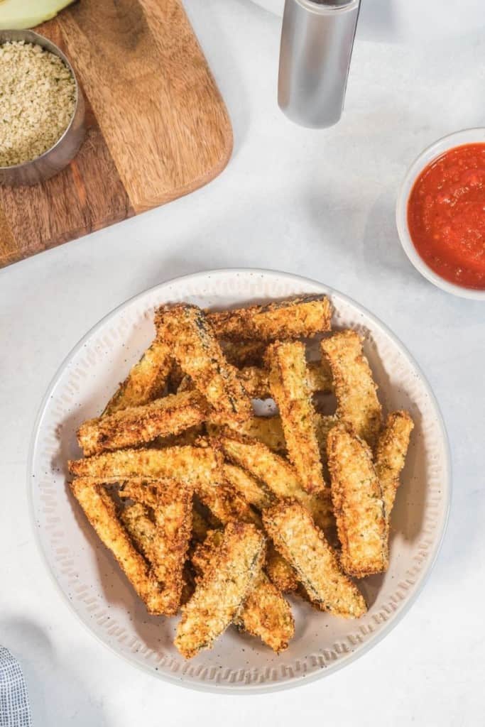 air fryer eggplant fries on plate with dipping sauce on the side