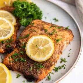 air fryer frozen salmon fillet on plate with lemon slices