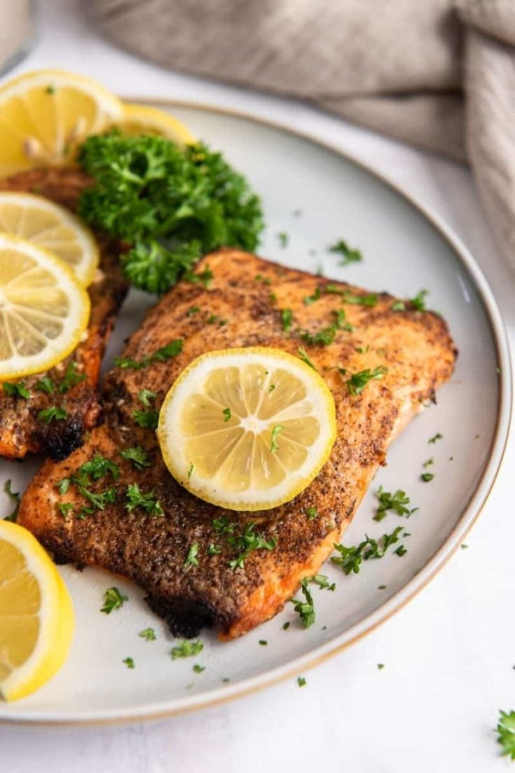 air fryer frozen salmon fillet on plate with lemon slices
