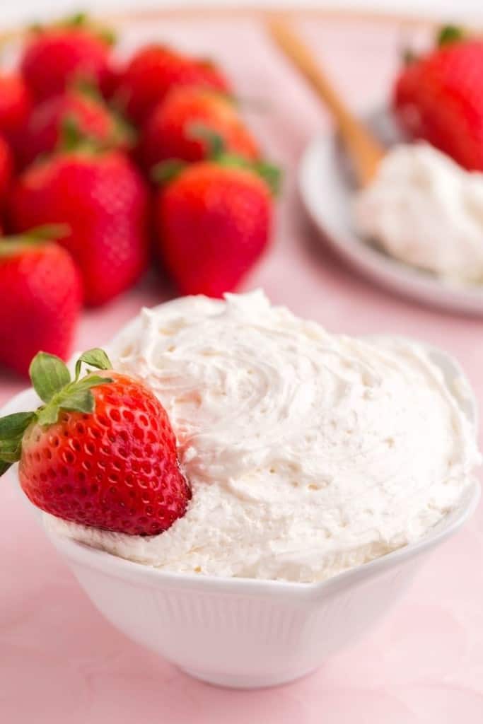 strawberry resting in bowl of cool whip fruit dip