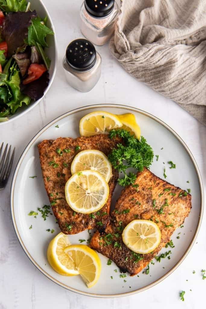 plate with two air fryer salmon fillets with lemon slices