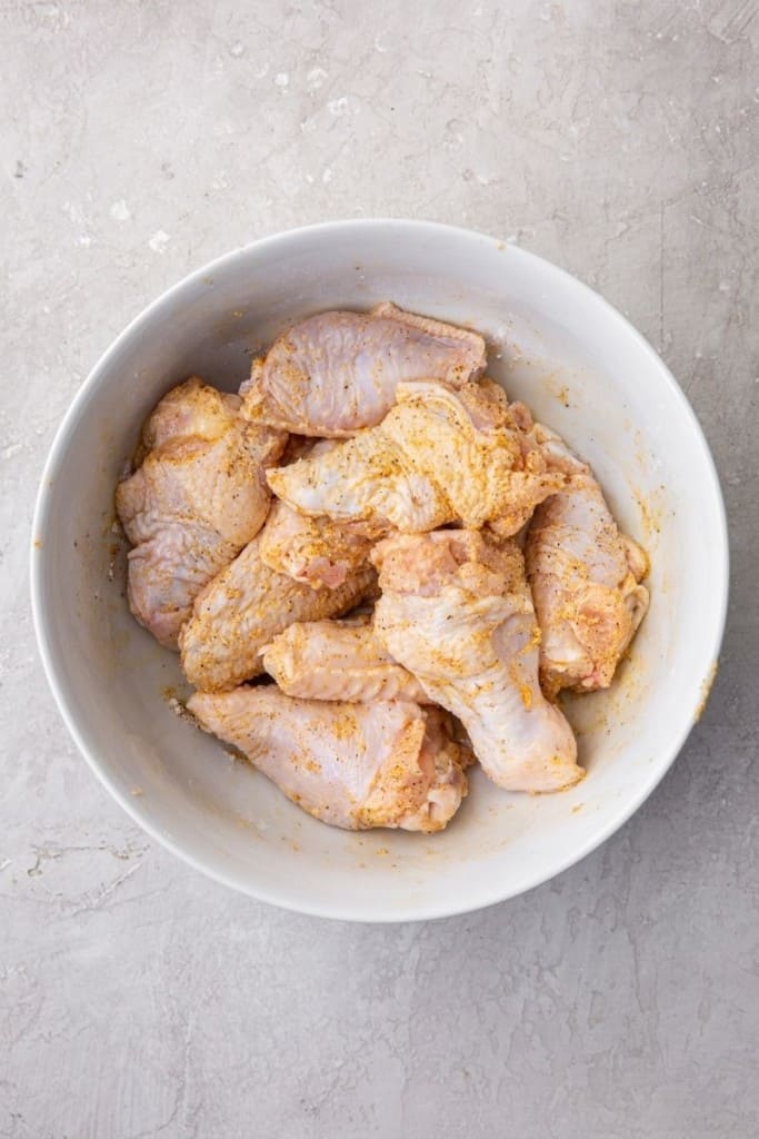 coat chicken wings with seasoning mixture