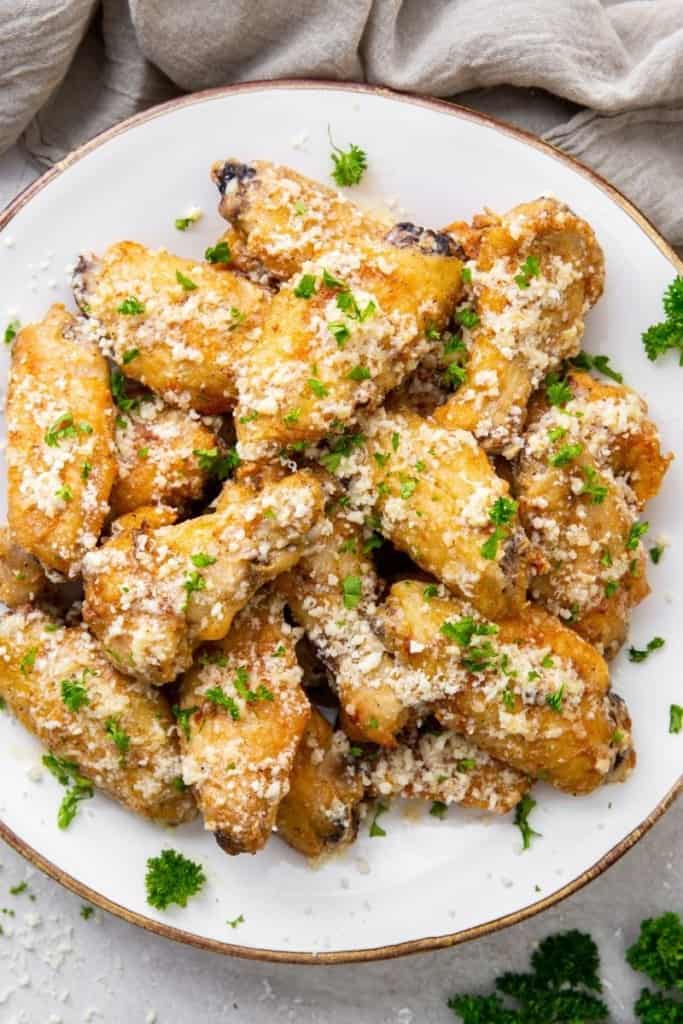 white plate full of garlic parmesan chicken wings cooked in air fryer