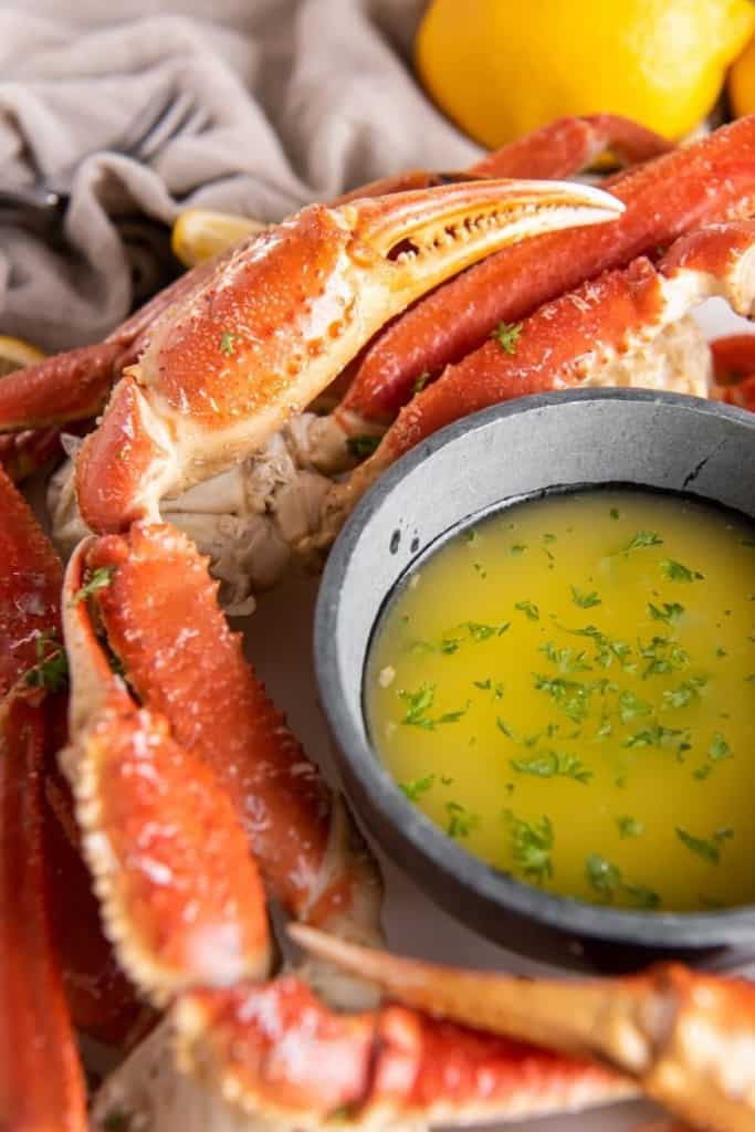 Sweet and succulent crab legs placed around garlic butter sauce