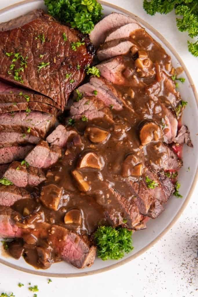 London broil cooked in instant pot on plate in slices with sauce