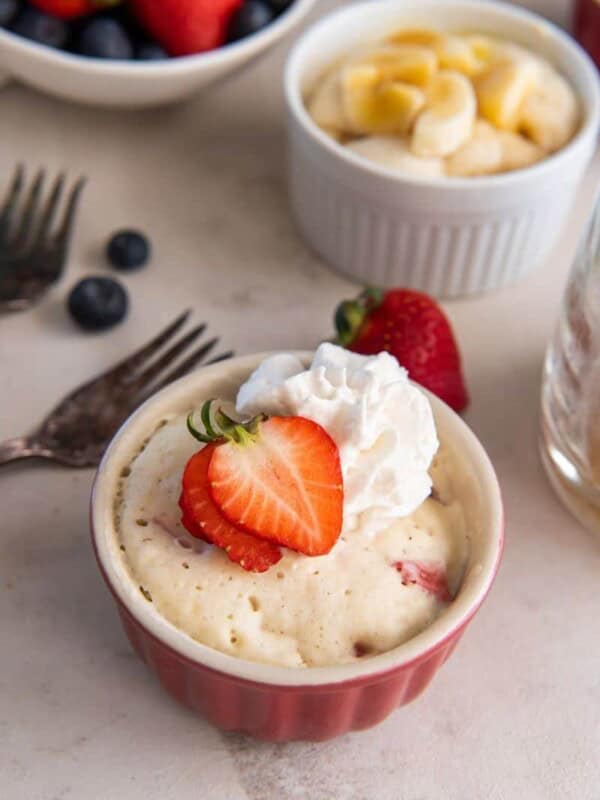 Several pancakes in mugs with different fruit toppings