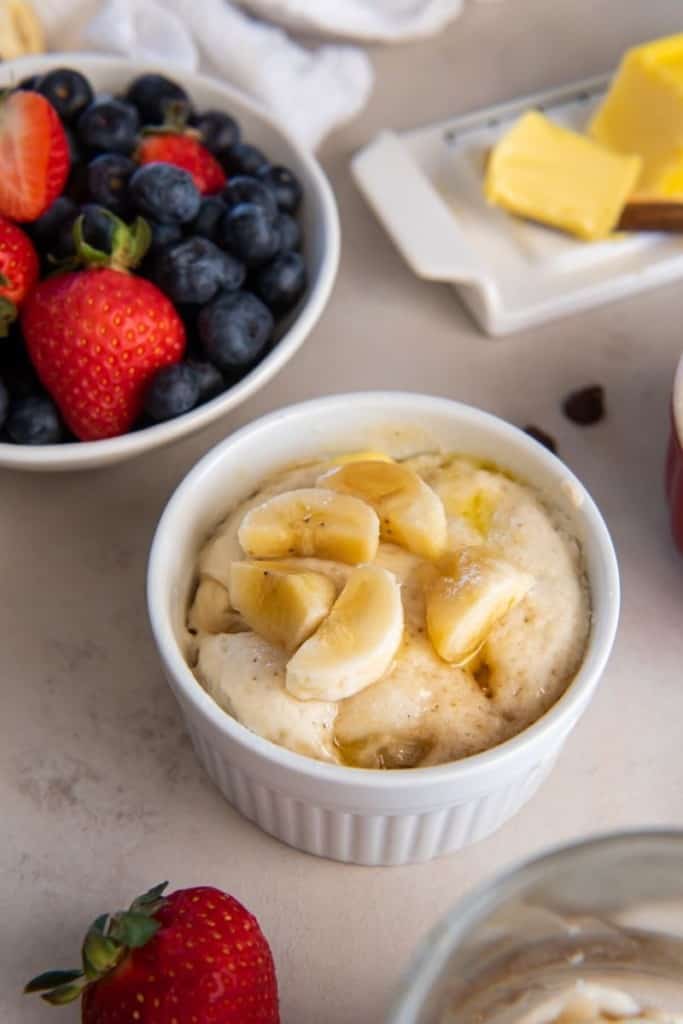 pancake in a mug with banana wedges with fruit bowl nearby