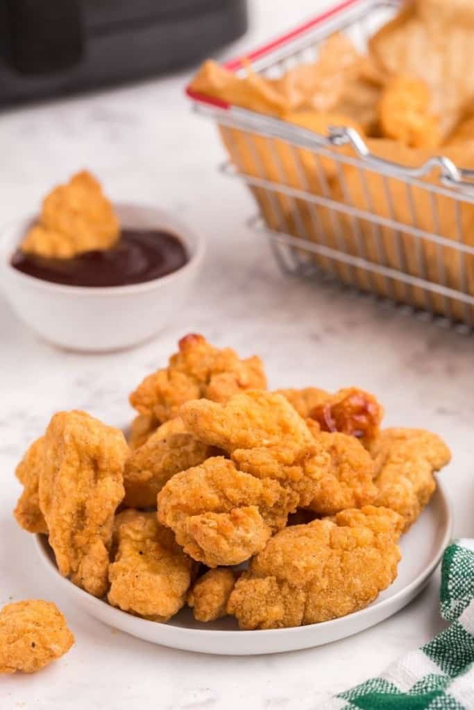 popcorn chicken in bowl with bbq sauce on the side