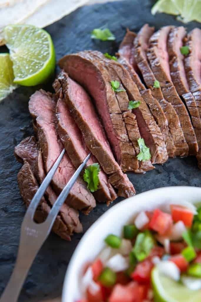 Juicy slices of air fryer skirt steak with carving fork