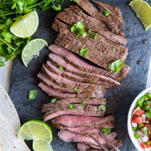 sliced air fryer skirt steak with lime wedges