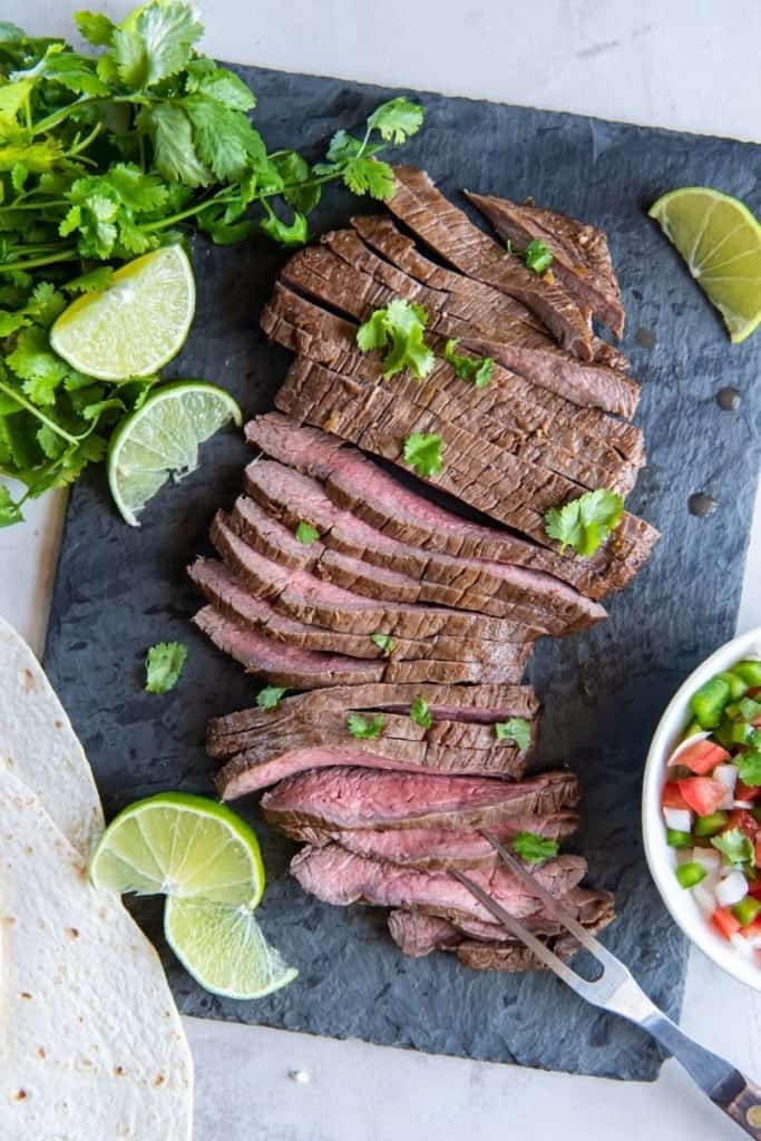 sliced air fryer skirt steak with lime wedges