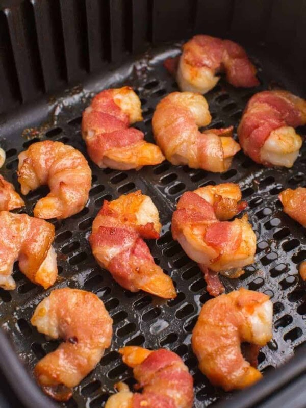 flip bacon-wrapped shrimp, add more glaze, and cook longer