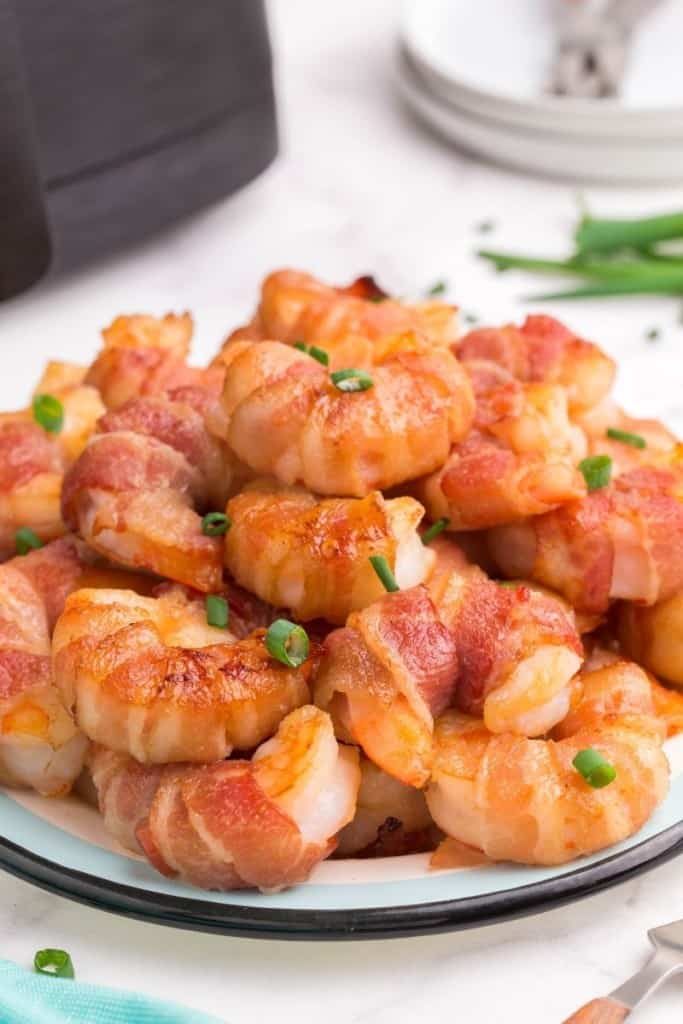 pile of air fryer bacon-wrapped shrimp on plate