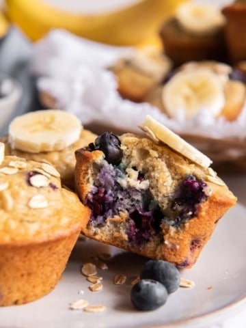 Banana blueberry oatmeal muffin on plate with bite taken out