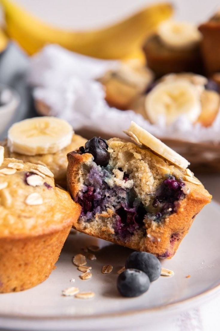 Banana blueberry oatmeal muffin on plate with bite taken out