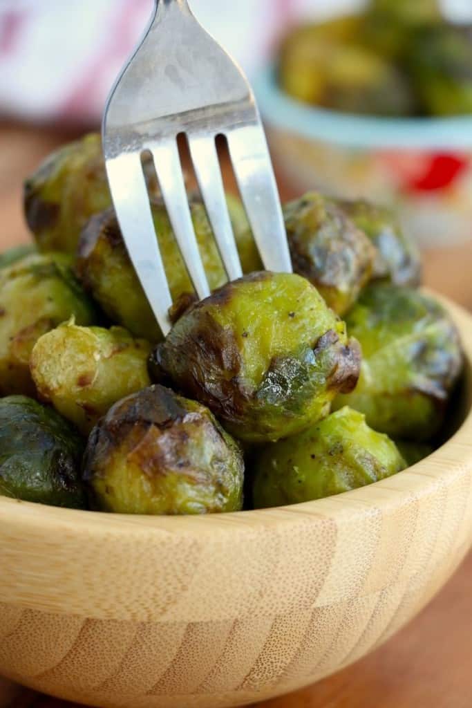 Brussel sprouts cooked in air fryer in bowl with fork