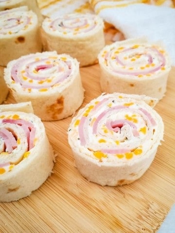 Ham and cheese roll-ups displayed on cutting board