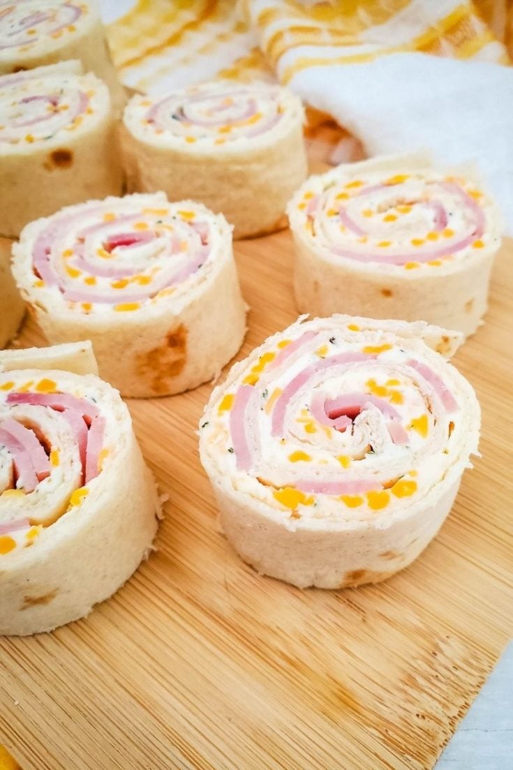 Ham and cheese roll-ups displayed on cutting board