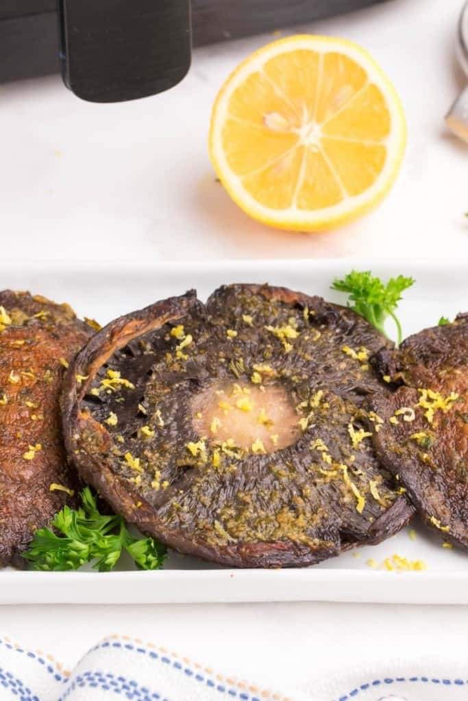 air fryer portobello mushroom on plate with lemon wedge