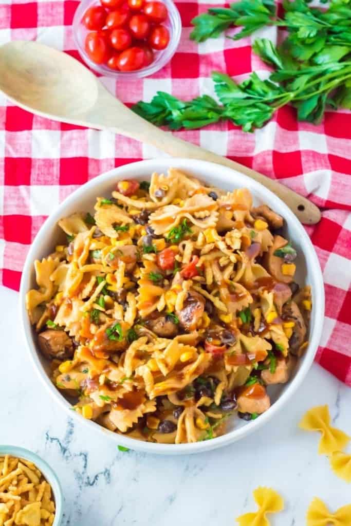 large white bowl of BBQ chicken salad on red checkered tablecloth