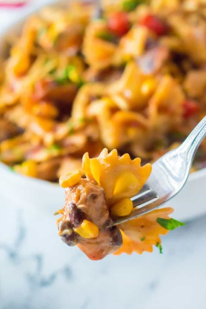 fork with bite of BBQ chicken salad from bowl