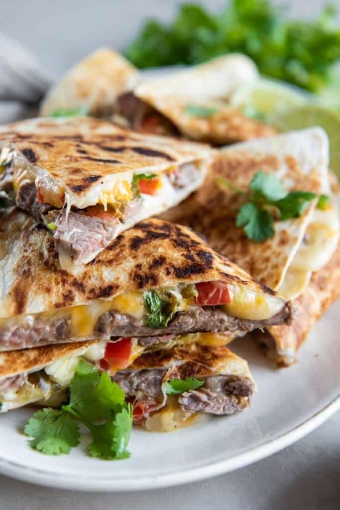carne asada quesadilla triangles stacked on plate