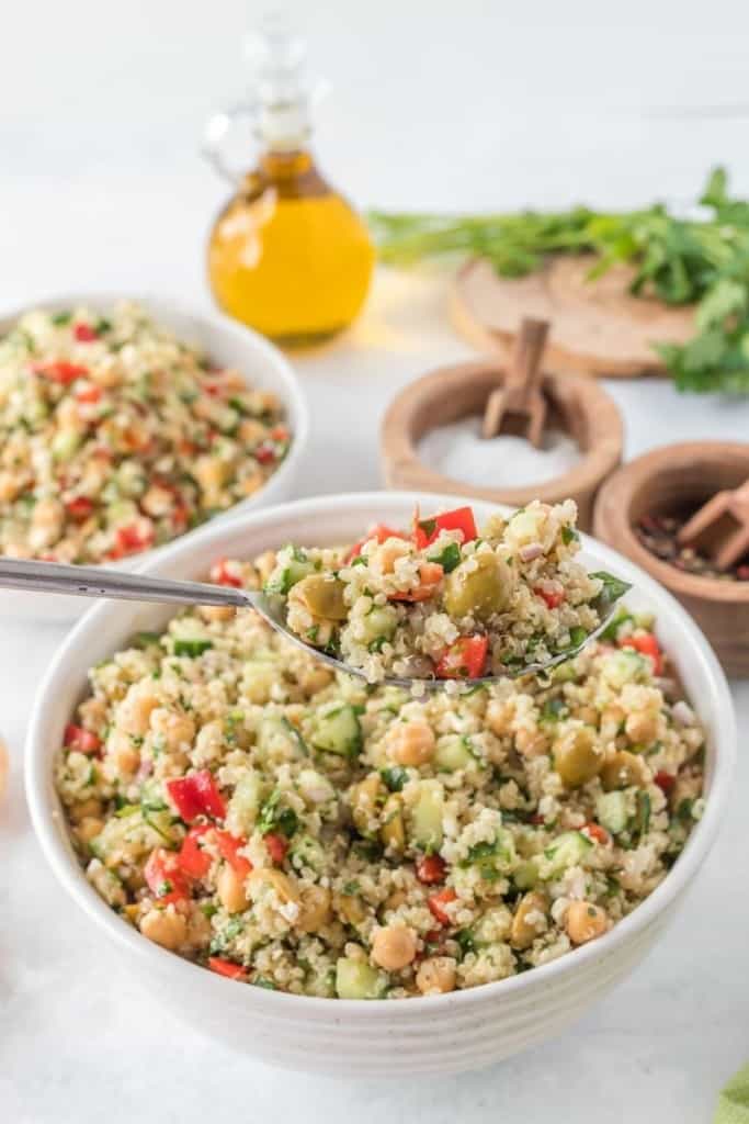 quinoa chickpea salad in bowl with salt and pepper on the side