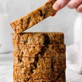 Someone taking slice of zucchini bread from a stack