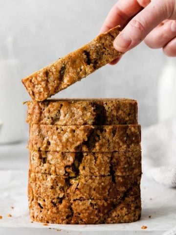 Someone taking slice of zucchini bread from a stack