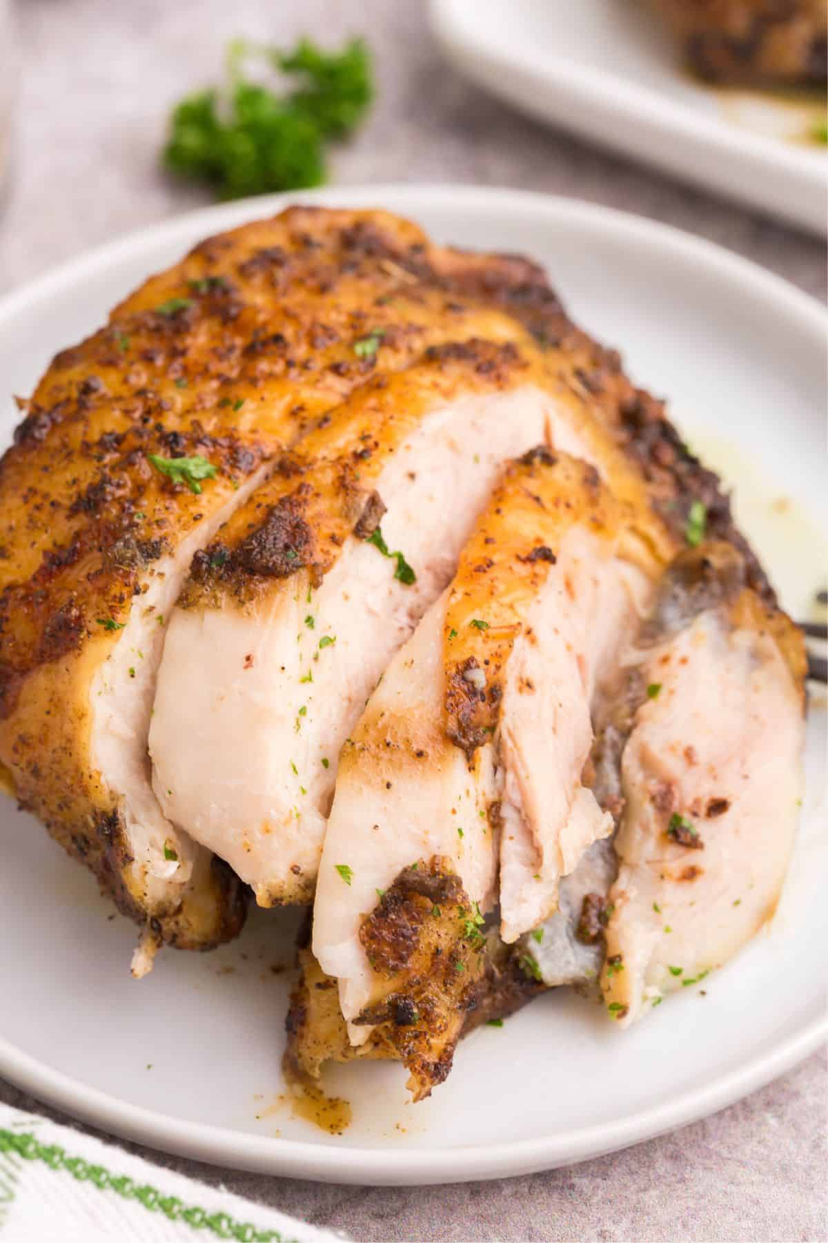 Bone in chicken thighs made in the air fryer cut into pieces on a plate.