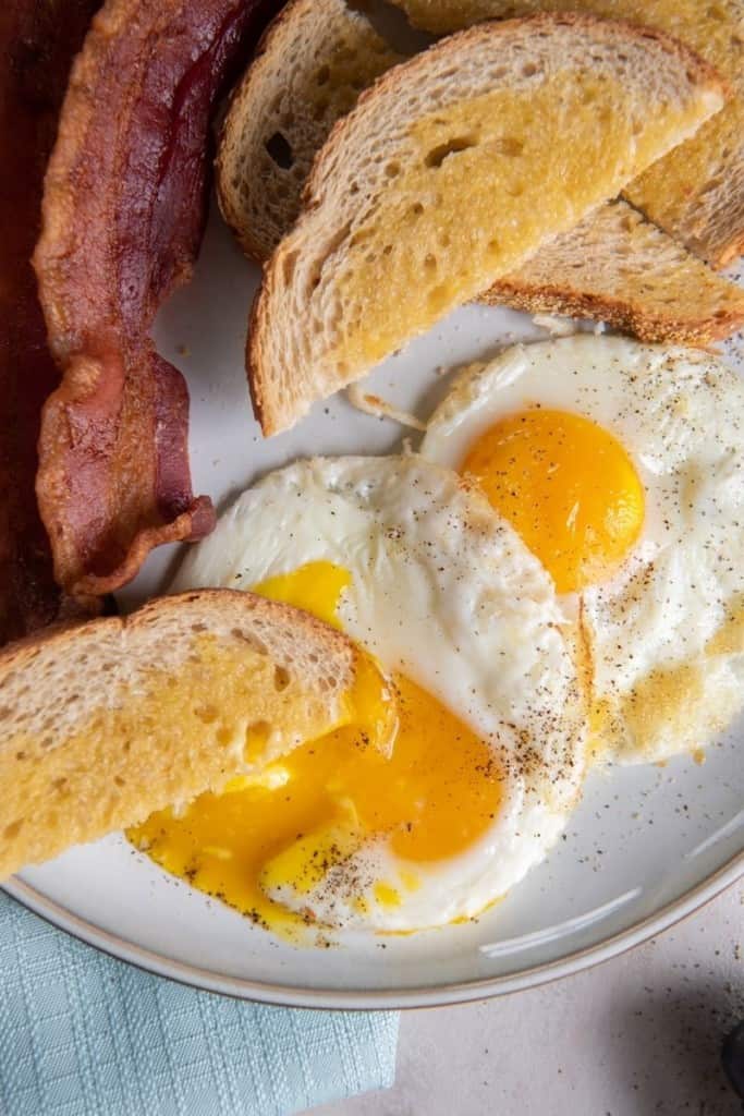 piece of bread soaking up cracked yolk of air fryer fried egg