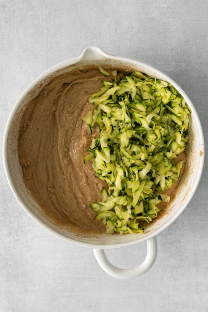 Zucchini bread batter with the shredded zucchini pieces being mixed in.