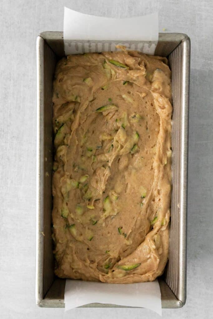 Raw zucchini bread in a bread loaf pan ready to be baked.
