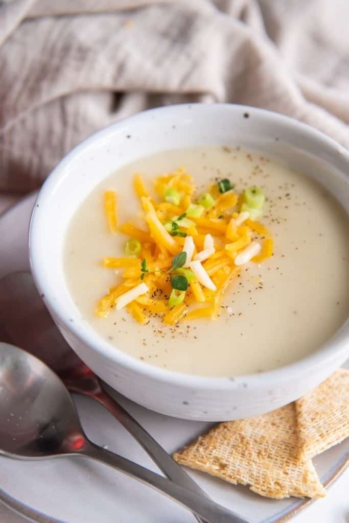 white bowl of 4 ingredient potato soup with toppings