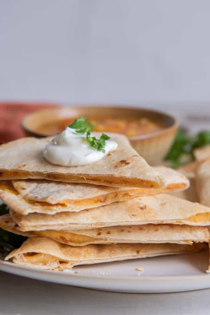 Air fryer quesadilla cut into pieces stacked on top of each other so you can see the cheese on the sides.