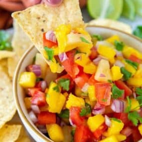 Chip being dipped in mango habanero salsa