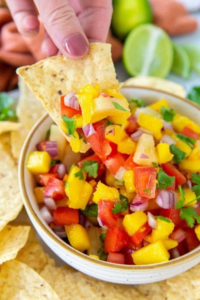 Chip being dipped in mango habanero salsa