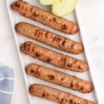 air fryer chicken sausages lined up on white plate