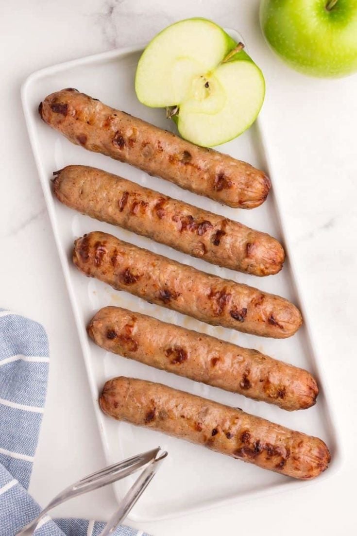 air fryer chicken sausages lined up on white plate