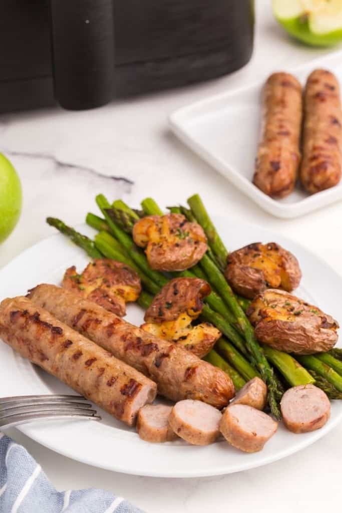 white plate with air fryer chicken sausage and asparagus