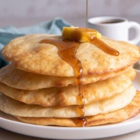 syrup pouring over stack of air fryer pancakes