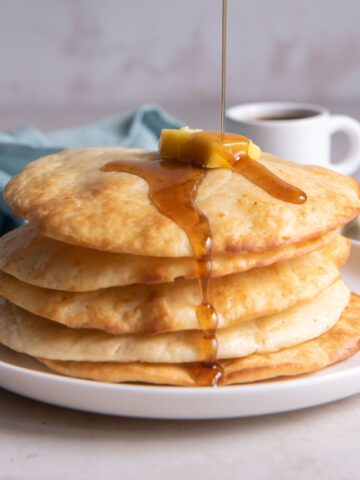 syrup pouring over stack of air fryer pancakes