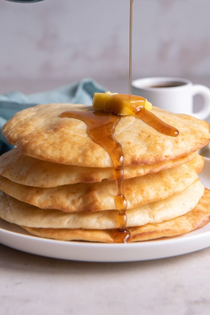 syrup pouring over stack of air fryer pancakes