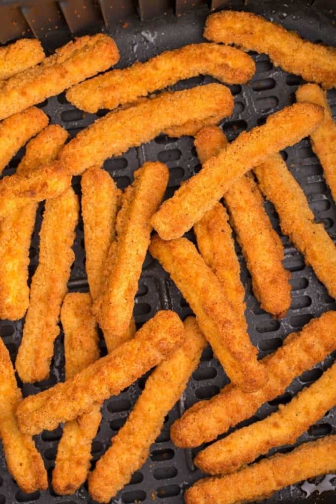 close up of chicken fingers cooking in air fryer