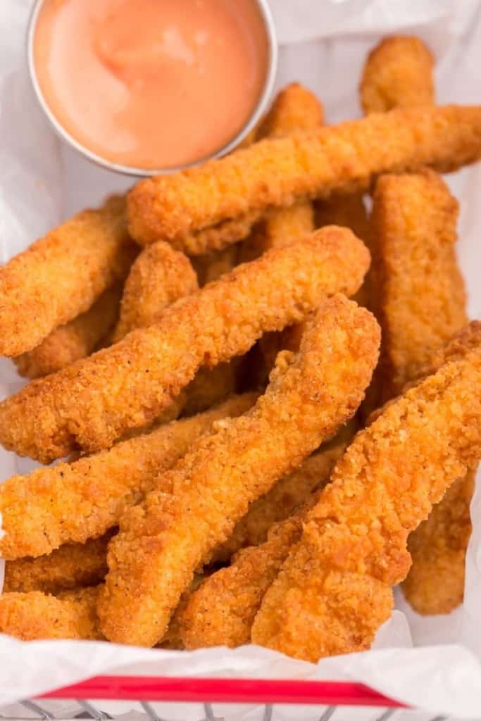 close up of crispy chicken fingers with dipping sauce